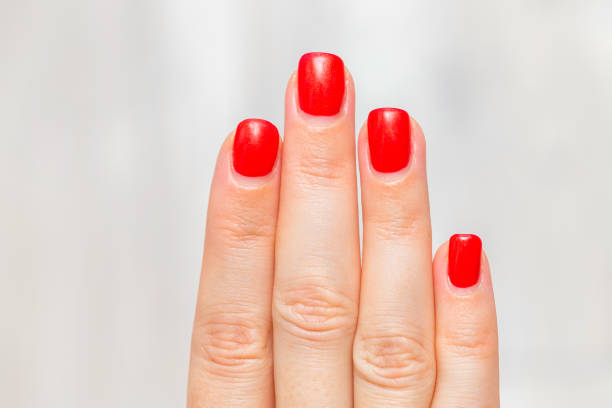 grown out red female manicure, close up. women's nails red. grown out manicure.