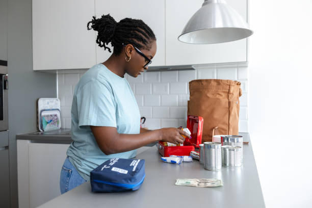 istock Person preparing essential supplies on a kitchen counter for emergency readiness 2192275387