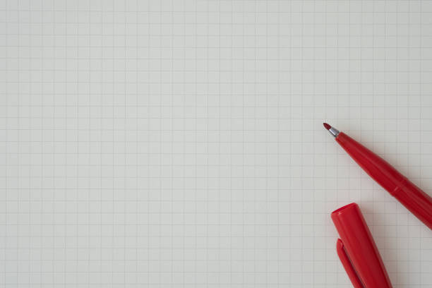 Top view, Close-up of Red Felt-tip Pen on Graph Paper, Empty Space for Text, Flat Lay Concept.