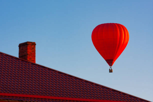 istock Bright Red Hot Air Balloon Above Rooftop 2192276583