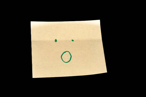 Yellow sticky note on a black background, featuring simple hand-drawn dots as eyes and a circle as a mouth, creating an expression of surprise or admiration