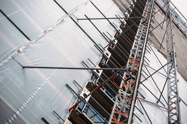 istock Scaffolding and protective plastic sheeting covering building during renovation 2192279071