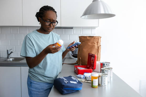 istock Woman checking medicine bottles in a kitchen setup for emergency preparation 2192281275