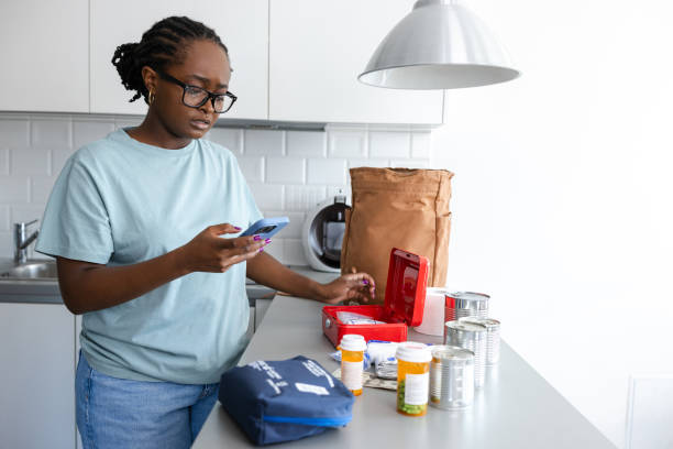 istock Young woman preparing emergency supplies while checking smartphone 2192281298