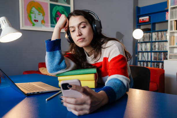istock Young woman in headphones relaxing with smartphone in a study environment 2192281510