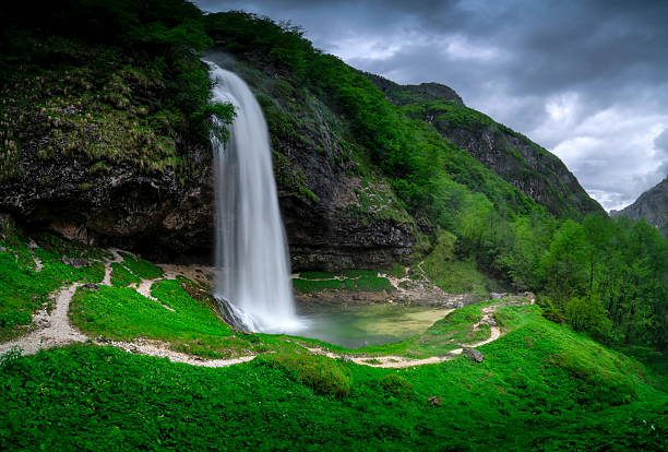 Beautiful Waterfall in green surroundings of mountains, Alps.