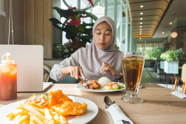 istock Young woman enjoying a meal in a modern cafe 2192287116
