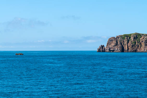 istock fishing boat and cliff on the sea 2192291826