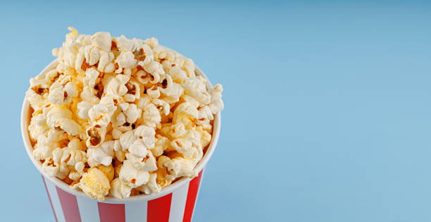 istock Classic red striped popcorn cardboard cup on blue background 2192292255
