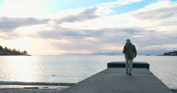 istock Mature man walks along pier at sunrise 2192296192