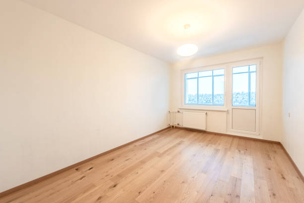 istock Bright Empty Room With Wooden Flooring and Large Window Overlooking Urban Scenery 2192297085