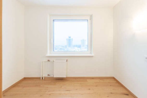 istock Bright Empty Room With Wooden Flooring and Large Window Overlooking Urban Scenery 2192297097