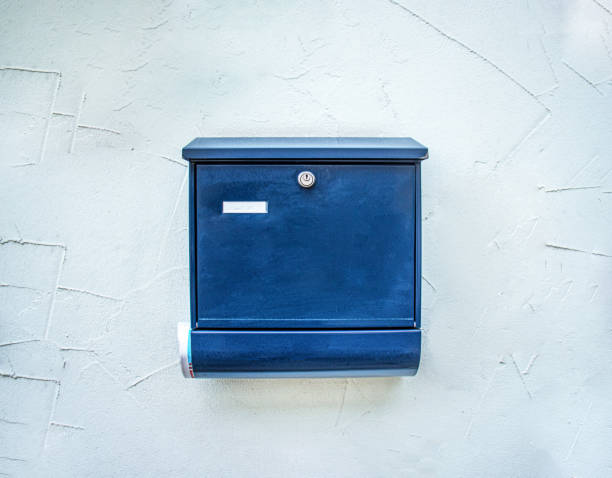 Rows of gray mailboxes with numbers in a residential building