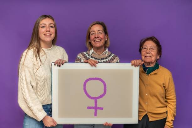 istock Three women holding a feminist symbol on purple background 2192301097