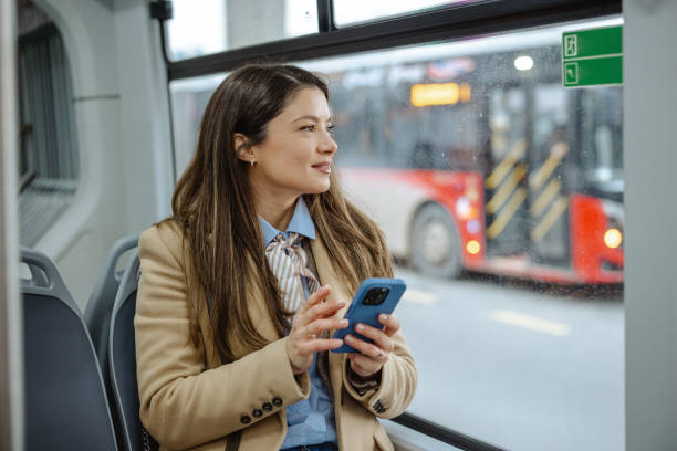 istock Woman using a smartphone while riding on a public transportation bus 2192304768