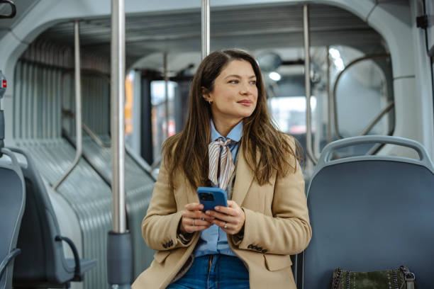 istock Beautiful woman using smartphone while commuting on a modern city bus 2192304813