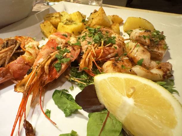 istock Grilled seafood platter with prawns and potatoes garnished with fresh herbs 2192305951