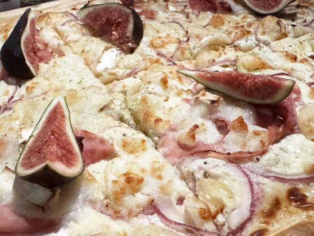 Gourmet pizza with figs, prosciutto, red onions, and mozzarella cheese