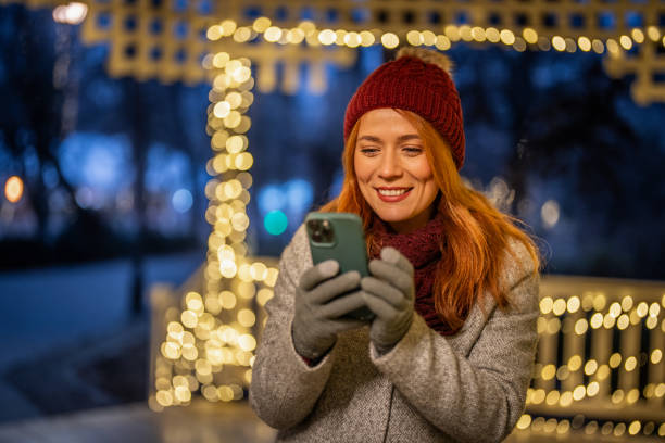 istock A girl with a phone, enjoying a festive environment 2192307238