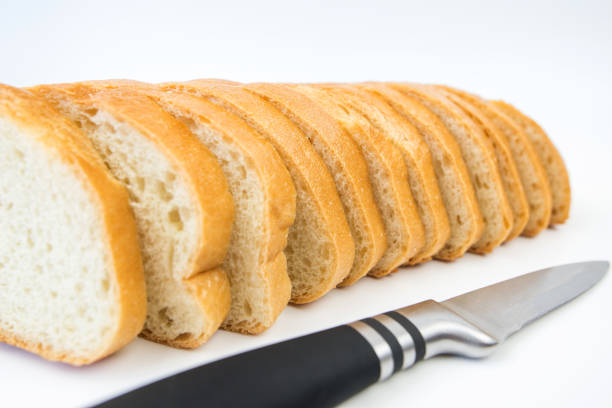 sliced bread and a knife on a white background. White bread slices. Baton on a white background.