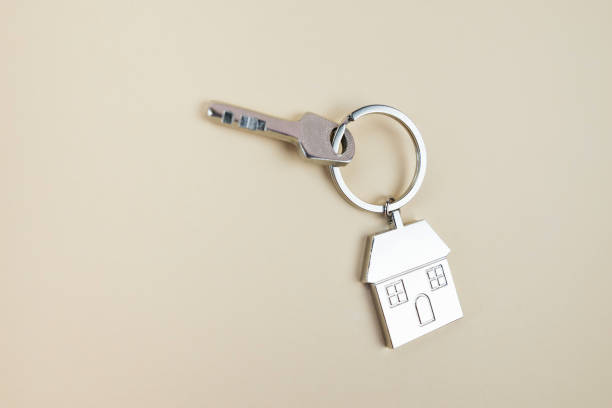 istock metal keychain house and keys on a beige background with copy space. 2192308228