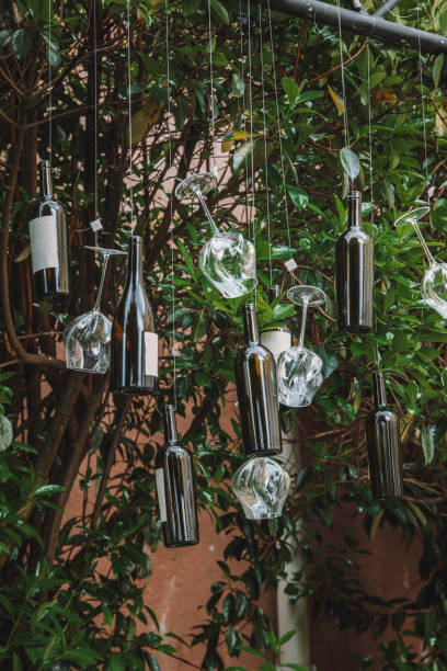 istock Wine Bottles and Glasses Hanging from Tree Branches in a Lush Garden 2192308337
