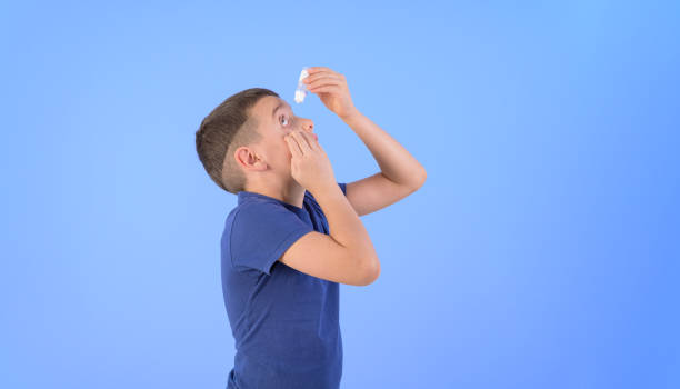 Senior man using eye drops.