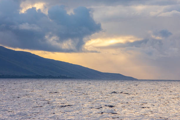 istock A moody Hawaiian Island cloudscape with sunbeams from a low angle sun. 2192313501