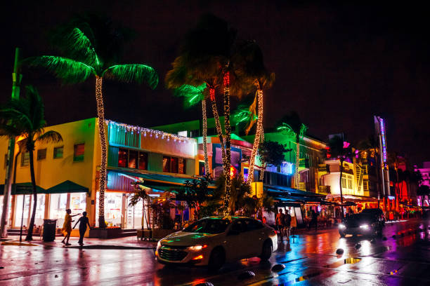 Miami Beach. USA. 02.26.2025. Light trails from passing cars on Collins Avenue at night near Lincoln Road in Miami Beach.
