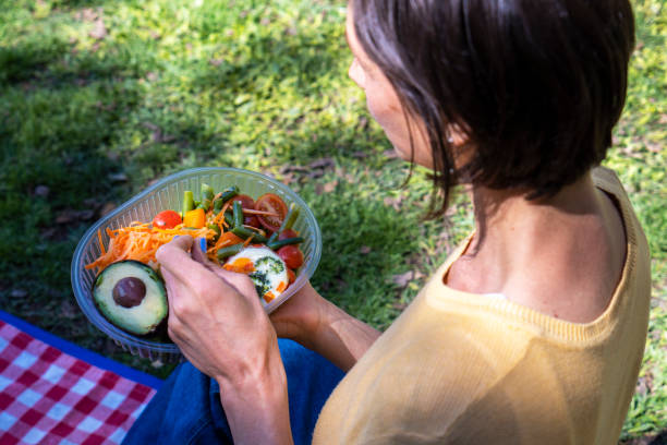 istock Enjoying a fresh salad outdoors on a sunny day in a park setting with vibrant greenery and picnic blanket 2192314882