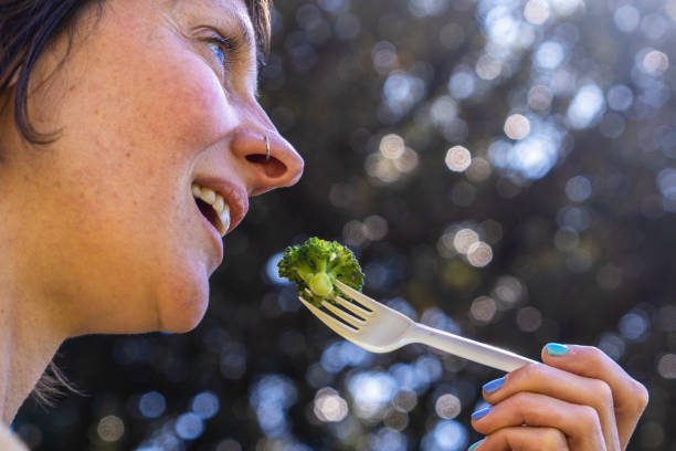 istock Woman enjoying fresh broccoli outdoors during a sunny day 2192314904