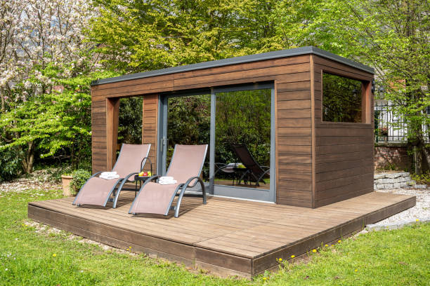 An inviting outdoor sauna at a boutique hotel, nestled in lush greenery, features lounging chairs and tranquil surroundings perfect for relaxation.