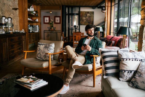 Young man using cell phone in the living room