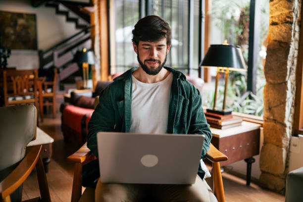 istock Young man working remotely in the living room 2192318431