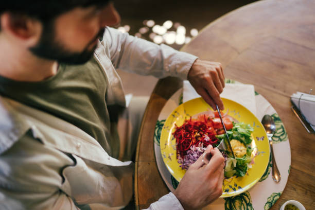 istock Young man eating a meal on a table 2192318884