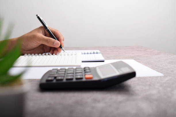 istock Businessman using a calculator to calculate numbers on a company's financial documents 2192325859