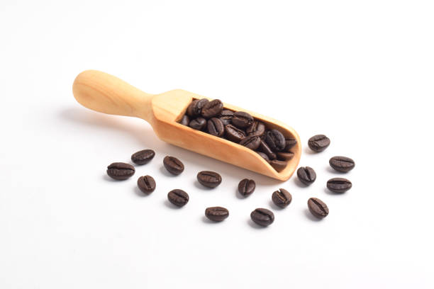 Roasted Coffee beans on wooden scoop isolated on white background