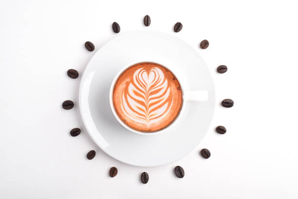 Coffee Mug with Latte Art and coffee beans on white background, forming clock dial. Top View