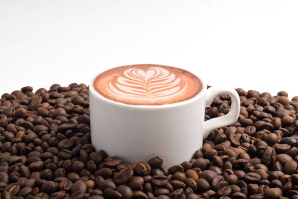 Cup of coffee placed on rich coffee beans isolated on white background