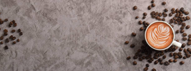 Horizontal banner with Cup of coffee and coffee beans on dark cement background. Top view. Copy space
