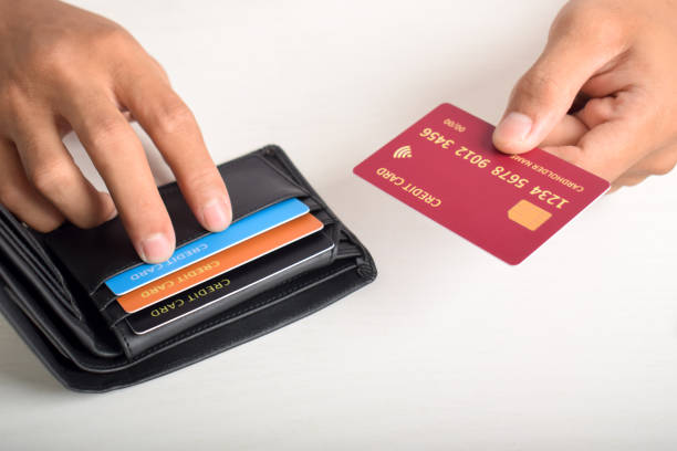 Cropped view of businessman giving credit card from wallet on table