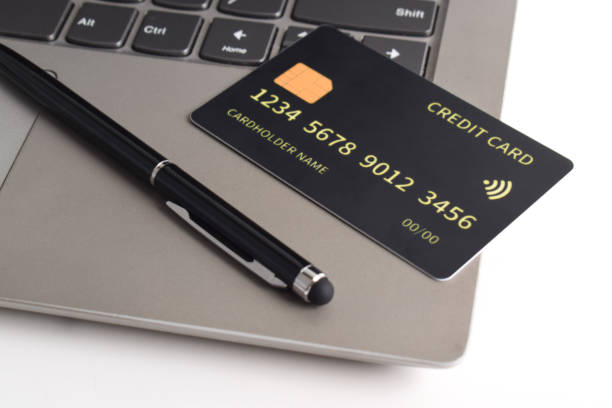 istock Black credit card on office table with laptop and pen 2192337412