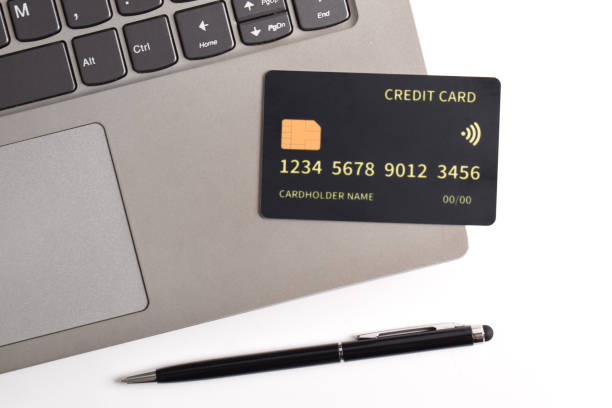 istock Black credit card on office table with laptop and pen 2192337422