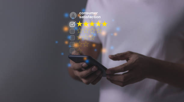 istock Consumer Satisfaction, Young Man hand using smartphone mobile with laptop to five star to review and give 5 stars with very good results in service, Good review 5 star rating choice feedback 2192344151