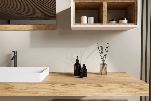 istock A minimalist wooden vanity featuring a rectangular white sink, black accents, and decorative vases. The close-up captures the sleek and modern design that complements contemporary interiors. 2192348704