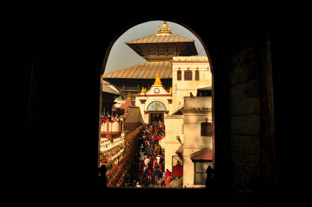 Pashupatinath Temple, Kathmandu: A sacred Hindu shrine seen through an arched opening. 1  Crowds of devotees gather at the ornate temple with its tiered roofs and golden spire.