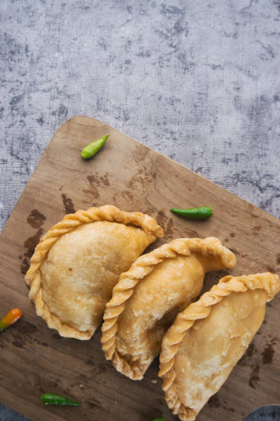 istock Golden Fried Empanadas on a Wooden Cutting Board 2192351153