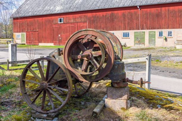 Old farm equipment and weathered buildings in arid field behind Hubbell trading post near Ganado Arizona.
