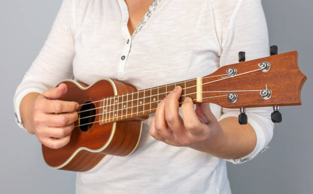 istock Anonymous close up of hands skillfully playing chords on a ukulele, showcasing the art of music and string instruments 2192358929