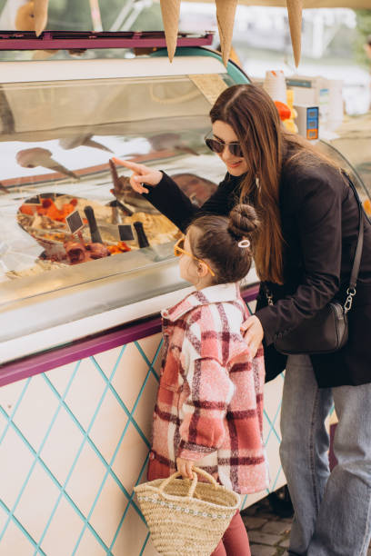 istock Mother and daughter choosing ice cream from a display case 2192363969
